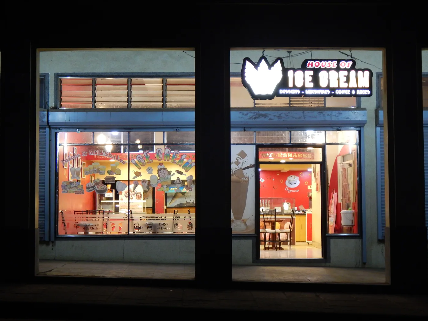 The House of Ice Cream shopfront at night, with the illuminated sign above the entrance.